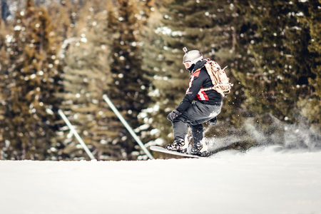 Young man rides snowboard and enjoying a frozen winter day on mountain slopes.の写真素材