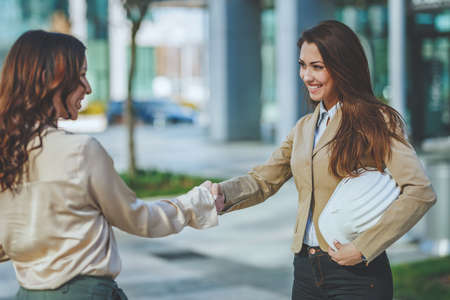 Two businesswomen are shaking hands with each other after good deal.の写真素材