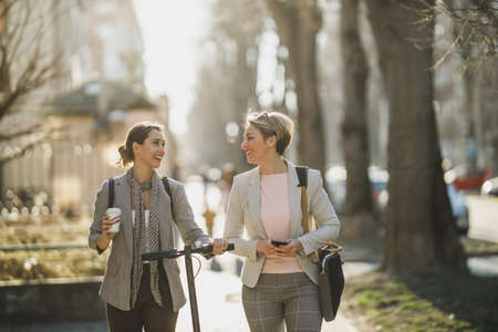 A two successful businesswomen chatting while walking through the city.の写真素材