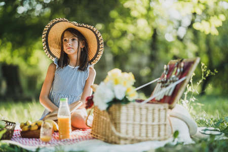 A cute pensive little girl spending a spring day in nature.の写真素材