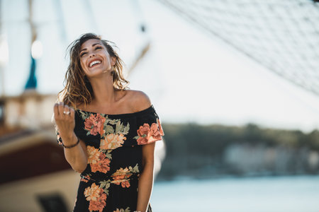 Young cheerful woman having fun and feeling playful while spending summer vacation at the shore.の写真素材
