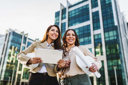 Two attractive smiling business woman having a business meeting and enjoying working together...