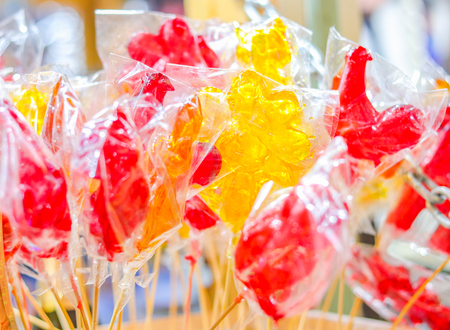 Lollipops cockerels on sticks yellow and red colors. Street foodの写真素材