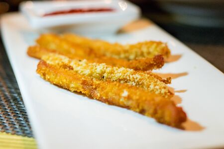 Long chicken nuggets strips with ketchup served on a white rectangular plate close upの写真素材