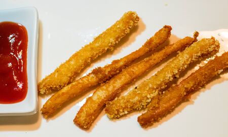 Long chicken crispy thin nuggets strips with ketchup on a white background. Top viewの写真素材