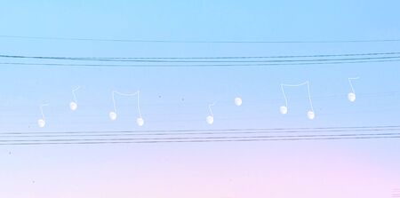 Melody of the moon. Creative manipulated surrealisstic abstract photo of the white moon on electric wires on a blues pink sky background. Copy space for text.の写真素材