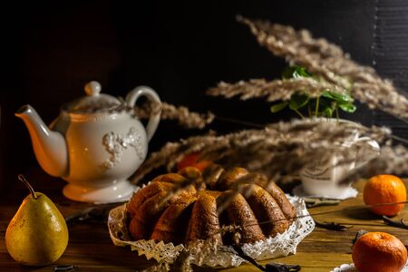 Rustic style traditional italian christmas pie cake pandoro with coffee green plant in stylish cup, white teapot in country style and fruits on clean black chalkboard menu background. Copyspace.の写真素材