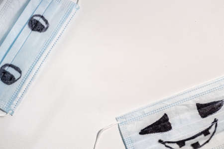 Protective medical facial blue masks with drawn scary halloween faces.