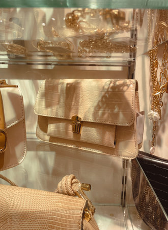 Fashion beige color woman small vintage purse on the store glass shelf in Italy.の写真素材