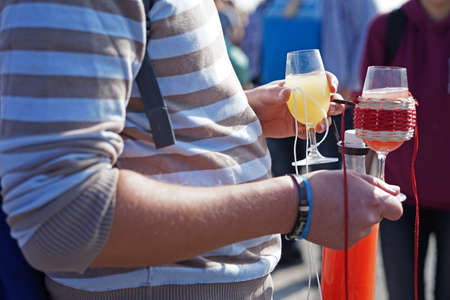 Man holding red and white young wine during autumn outdoor festival, Mutenice, Czech Republic