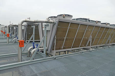 Industrial V-shaped chillers with fans cooling hot refrigerant on roof used in warehouse of food industryの写真素材