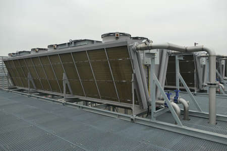 Industrial V-shaped air coolers with fans cooling hot refrigerant on roof used in warehouse of food industryの写真素材