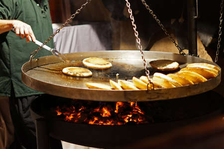 Detail of traditional arab pita flat bread frying above wooden coal in large panの写真素材