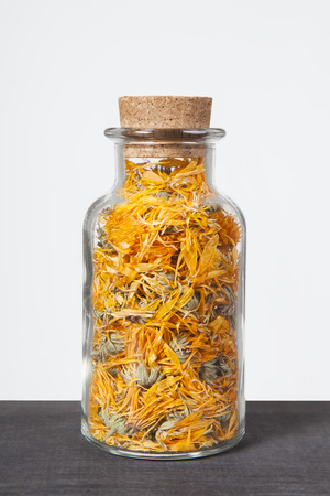 Dried calendula herb inside a glass jar. Herbs and plants for tea.の写真素材