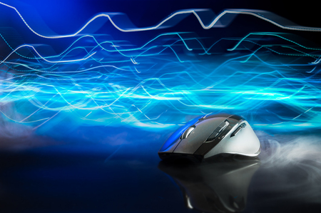 High technology computer gaming mouse in dark blue tone with stroke of lightning as background の写真素材