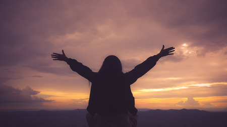 Silhouette freedom woman rise hands up to welcome a good day , open arms motivate enjoy and success the wishの写真素材