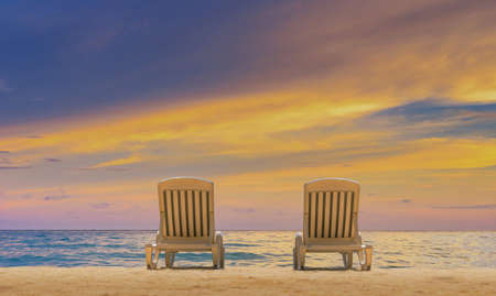 Couple of beach beds on tropical beach with beautyful twilight skyの写真素材