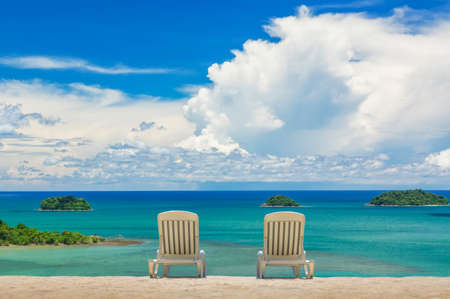 Couple of beach beds on tropical beach with beautyful blue skyの写真素材