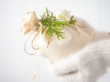 Hands in winter gloves holding a gift for Christmasの写真素材