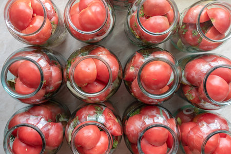 In a glass jar, red tomatoes for storage for the winter.の写真素材