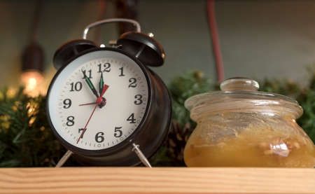 Decor in the studio on a wooden table. Watch and honey in a jar.