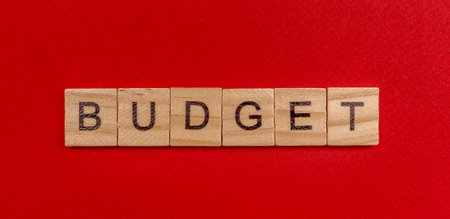 The inscription in wooden letters the word budget on a red background. Concept.の写真素材