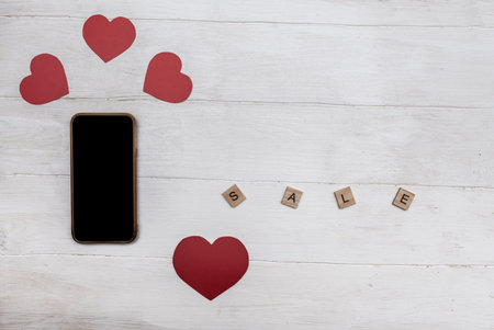 Valentine's Day. A discount. Telephone. Red hearts on white wooden background. Discount inscription.の写真素材