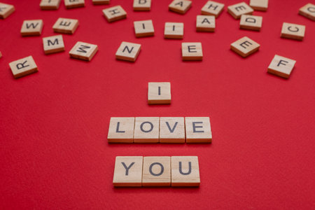 On a red background the inscription from wooden letters. I love you. Design for the holiday.の写真素材