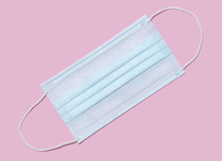 Medical disposable protective mask on a pink background. Covering the mouth and nose. Protection...
