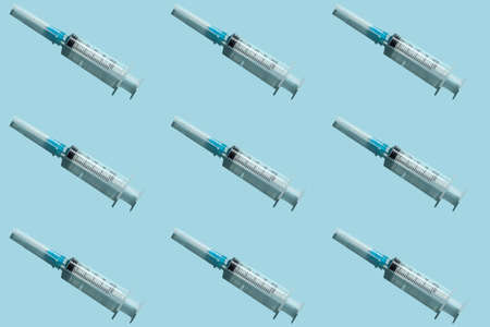 Medical syringe on a blue background. Medical equipment. Pattern.の写真素材