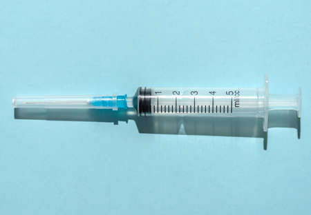 Medical syringe on a blue background. Medical equipment. For injection. Close-up.の写真素材