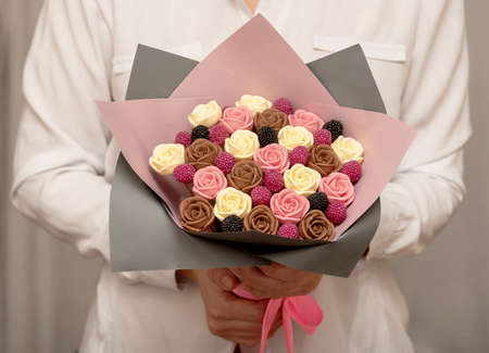 Female hands hold a sweet bouquet of chocolate roses. Celebration.の写真素材