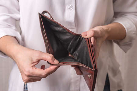 A woman in a white shirt is holding an empty wallet. Business problems.の写真素材