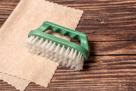 Brush and rag on a wooden brown background. House cleaning. Close-up.の写真素材