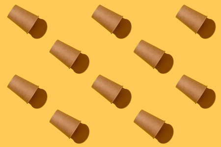 Pattern. Empty paper natural disposable craft brown glass. Yellow background.の写真素材