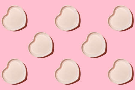 Heart shaped plate. Ceramic tableware. On a pink background. With a hard shadow. Pattern. View from...
