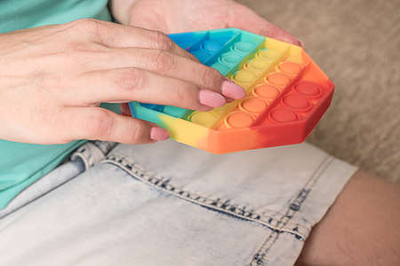 The woman's hands are holding a silicone toy on her lap. Woman is resting while sitting on the...
