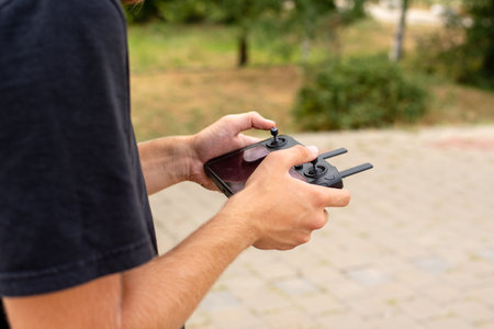 Male hands hold the joystick from the drone. In the summer on the street. High-tech innovation. remote control.の写真素材
