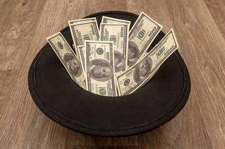 A black felt hat is lying on the floor with money. Vintage retro hat.の写真素材