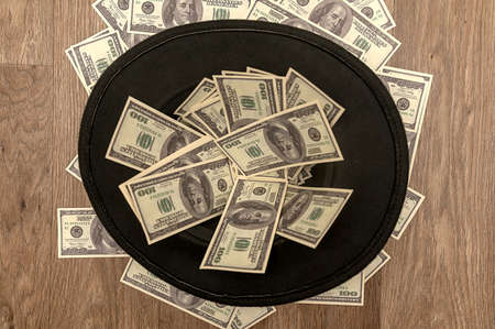 A black felt hat is lying on the floor with money. Vintage retro hat.の写真素材