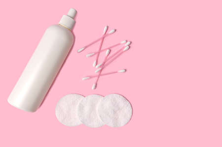 Cosmetic lotion, cotton pads, cotton swabs. Natural cosmetics concept. On a pink background.の写真素材
