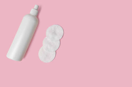 Cosmetic lotion, cotton pads. Natural cosmetics concept. On a pink background.の写真素材