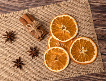 Dry orange oranges. Dried citrus fruits. Tropical fruit. Cinnamon sticks. On a brown background.の写真素材