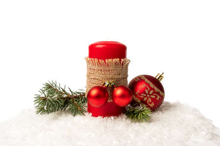 Red candles and branches of a Christmas tree on white snow. Christmas decorations. On white background.の写真素材