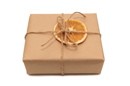 Kraft paper gift box with dried orange. On white paper.の写真素材