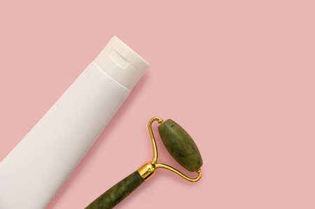 Cosmetic roller for the face, white container on a pink background.の写真素材
