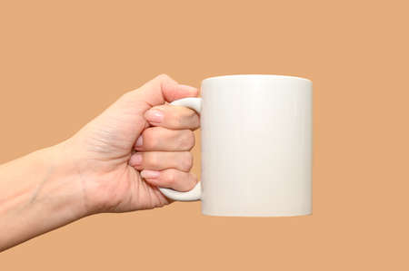 A female hand holds a white mug. Minimalism and space for text.の写真素材