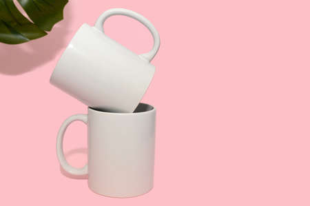 Two white mugs on a pink background. Mockup for design. close-up.の写真素材