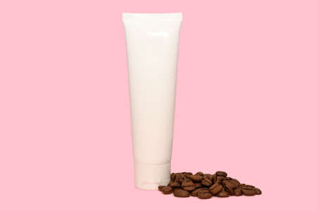 Organic cosmetics with coffee extract. Skin care cosmetic product and coffee beans. On a pink...