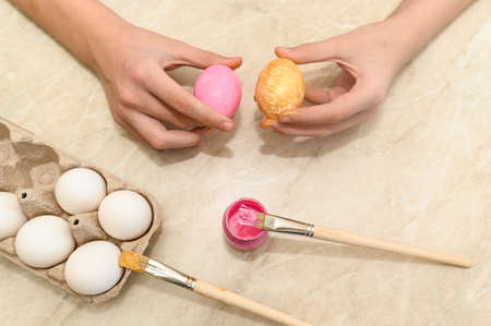 Easter. Coloring eggs for the holidays. family celebration. Color the egg pink and gold.の写真素材